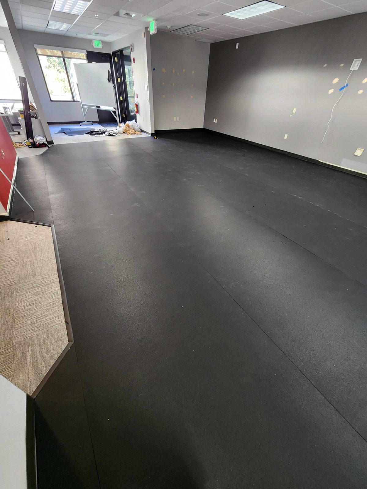 Finished commercial rubber flooring installed across a large multi-purpose office room