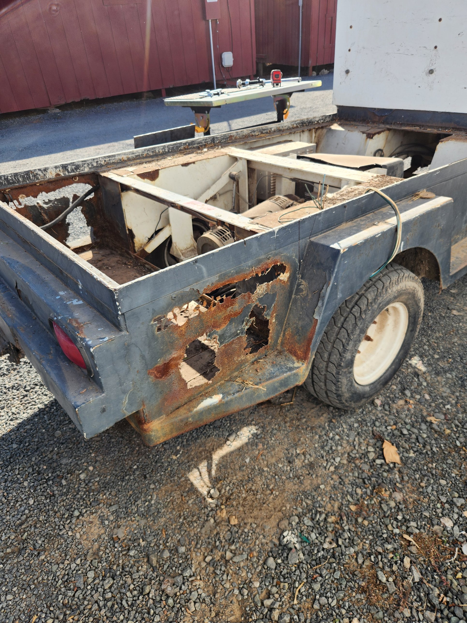 Rusted-out battery compartment corner on a golf cart before repair