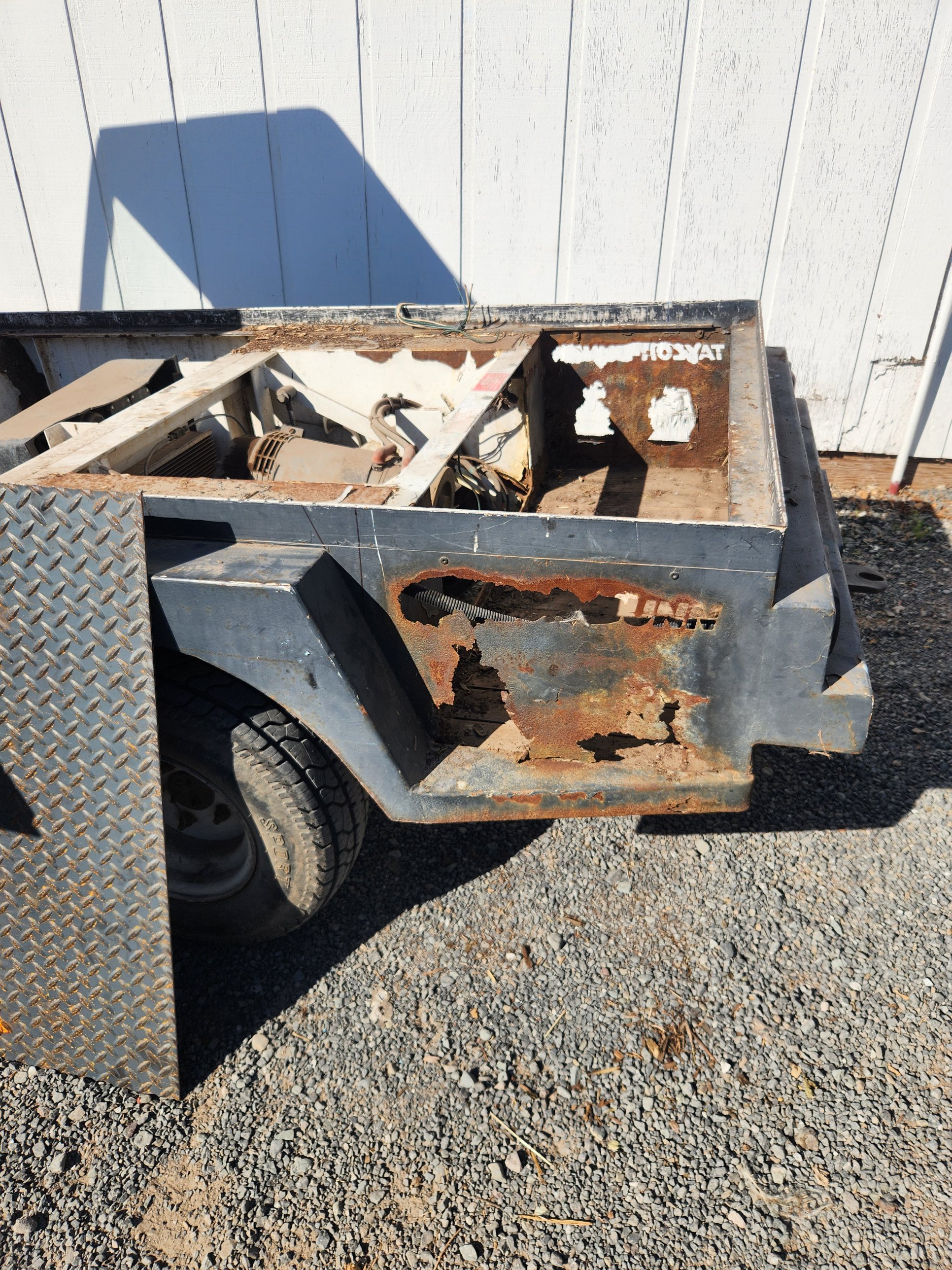 Close-up of rusted-through steel on a golf cart battery compartment panel before repair in Petaluma
