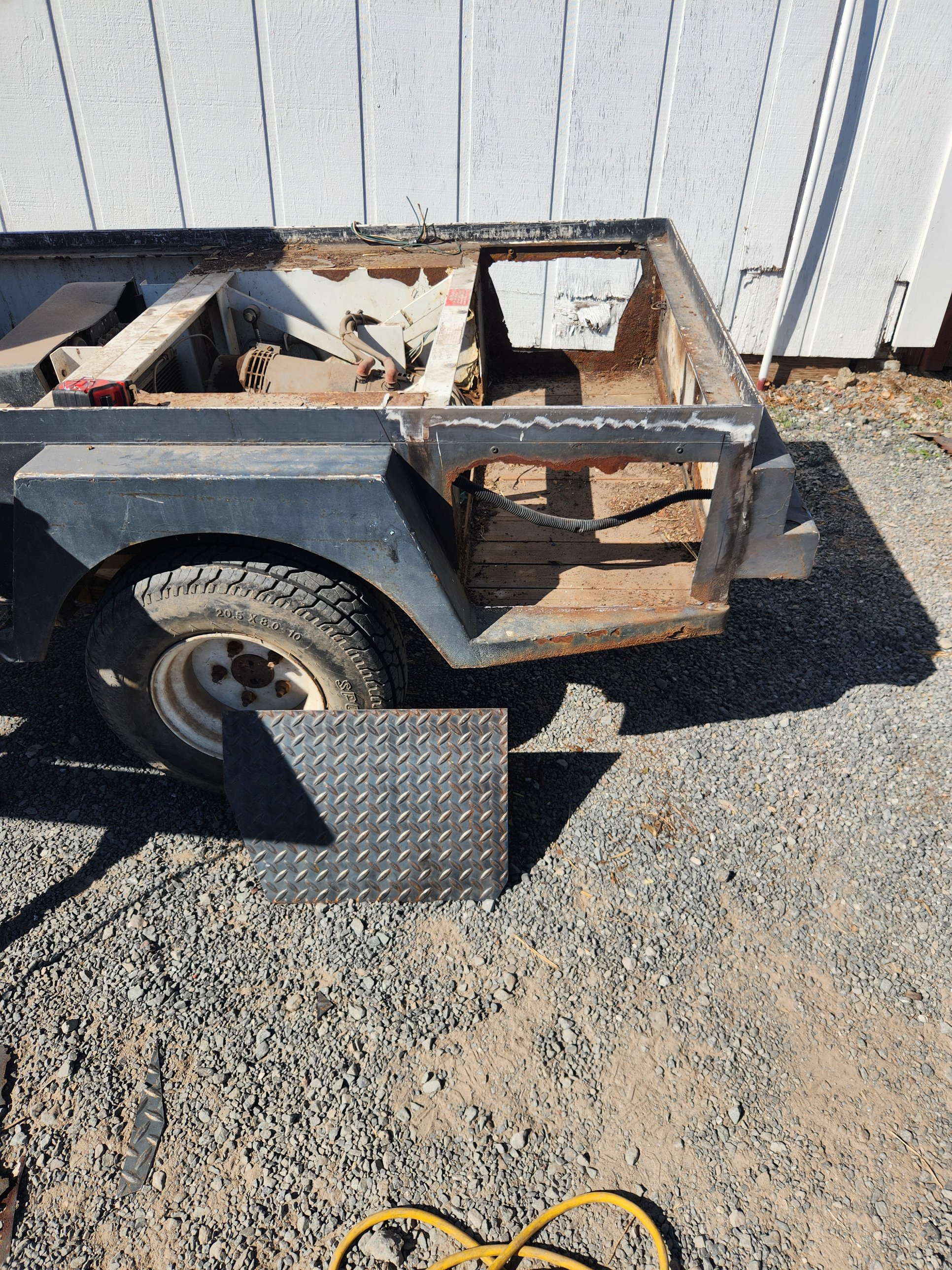 Golf cart battery compartment with rotted steel cut out before welding in new plate in Petaluma