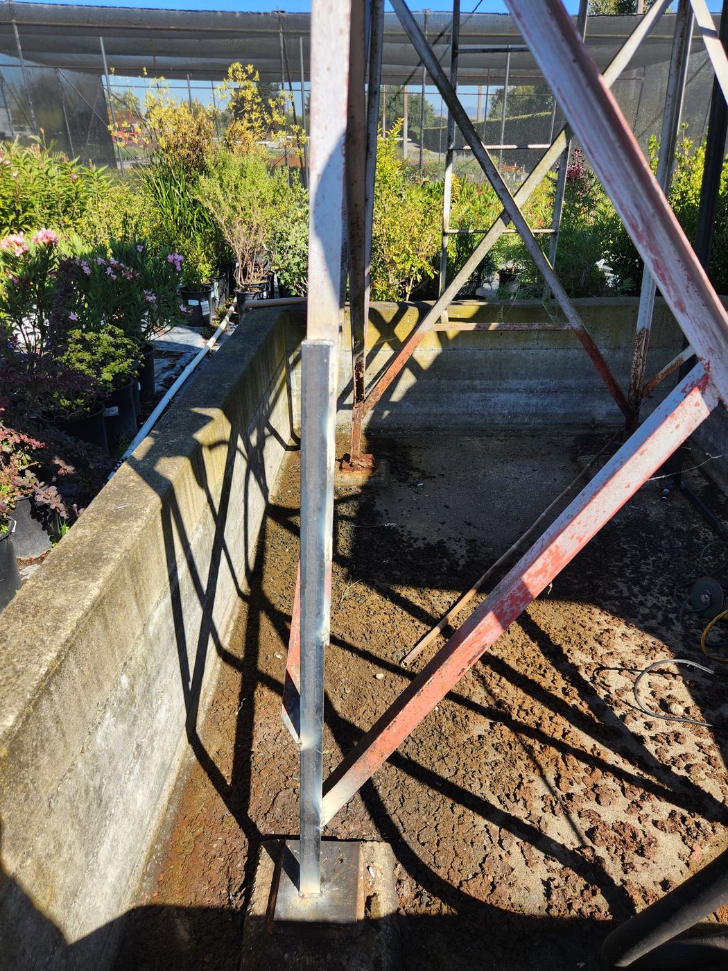 New welded steel base plate on a replaced angle-iron corner post, other posts still original