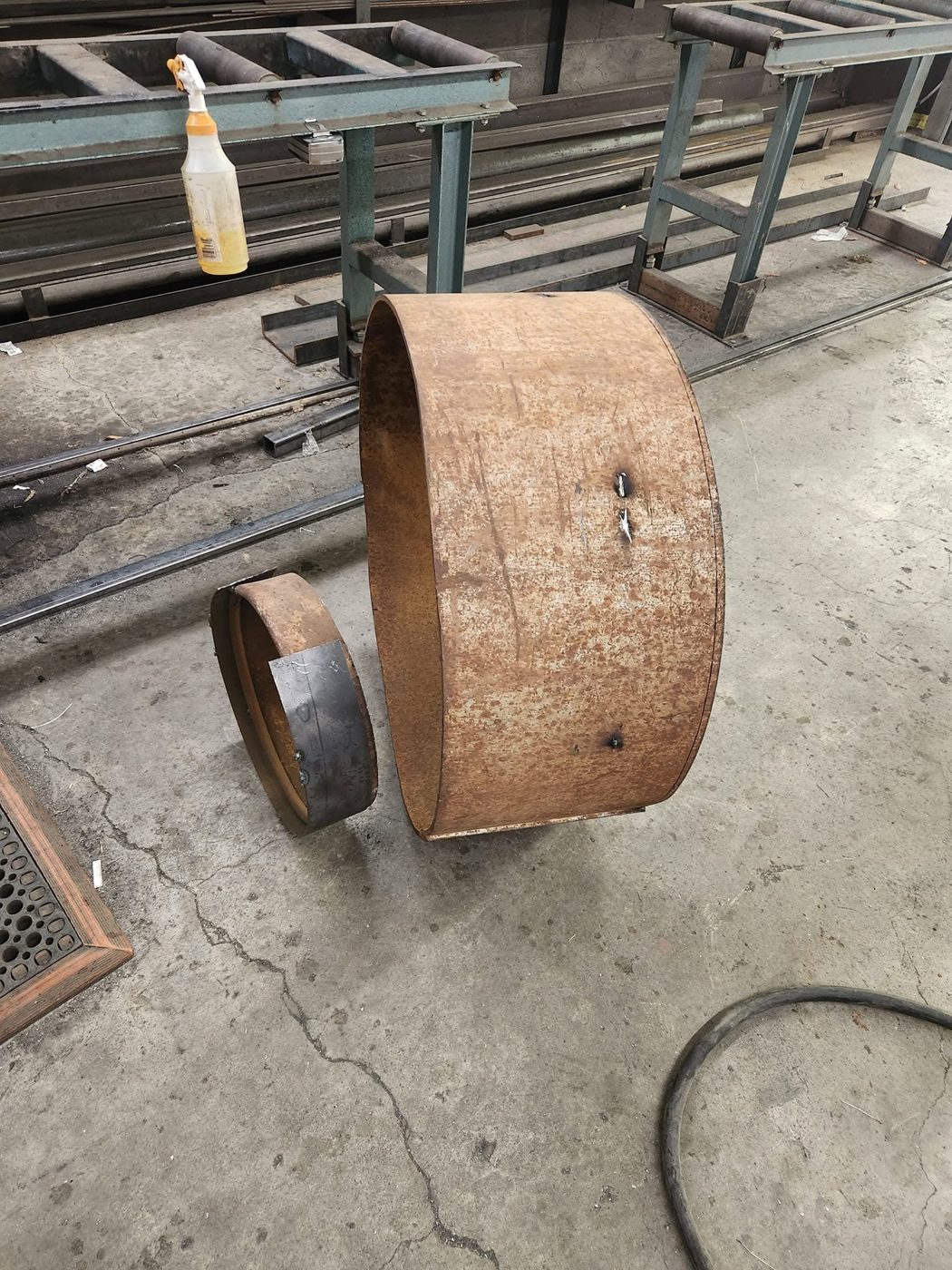 Rusted propane tank cut apart, with the top section set aside