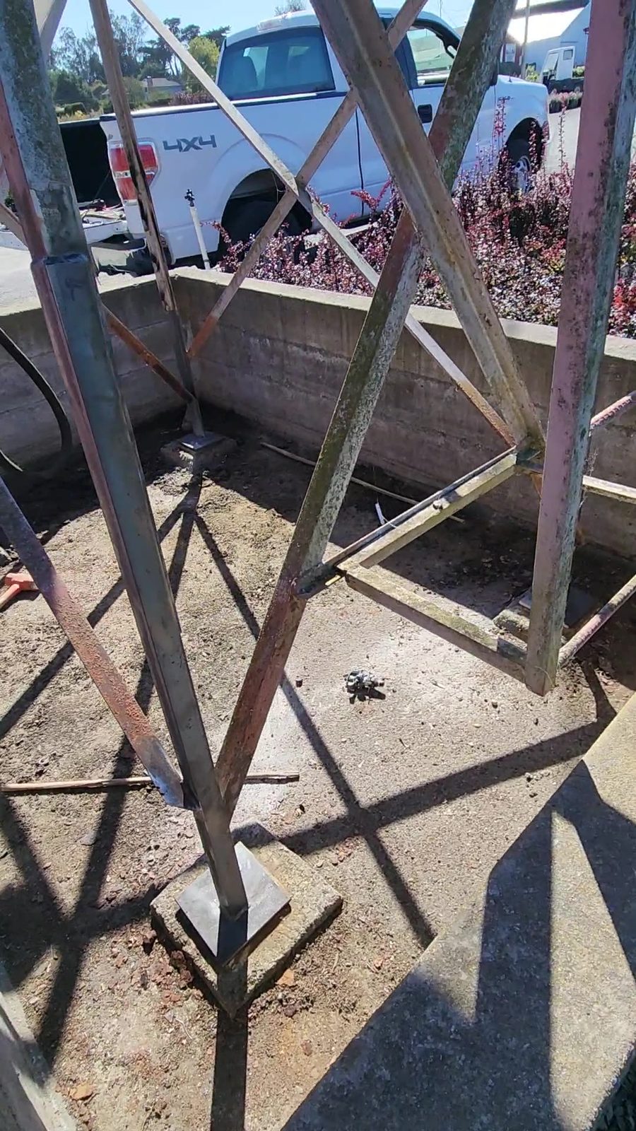 Wide view of the repaired diesel tank stand with new welded base plates on every corner, work truck on site, Sonoma County