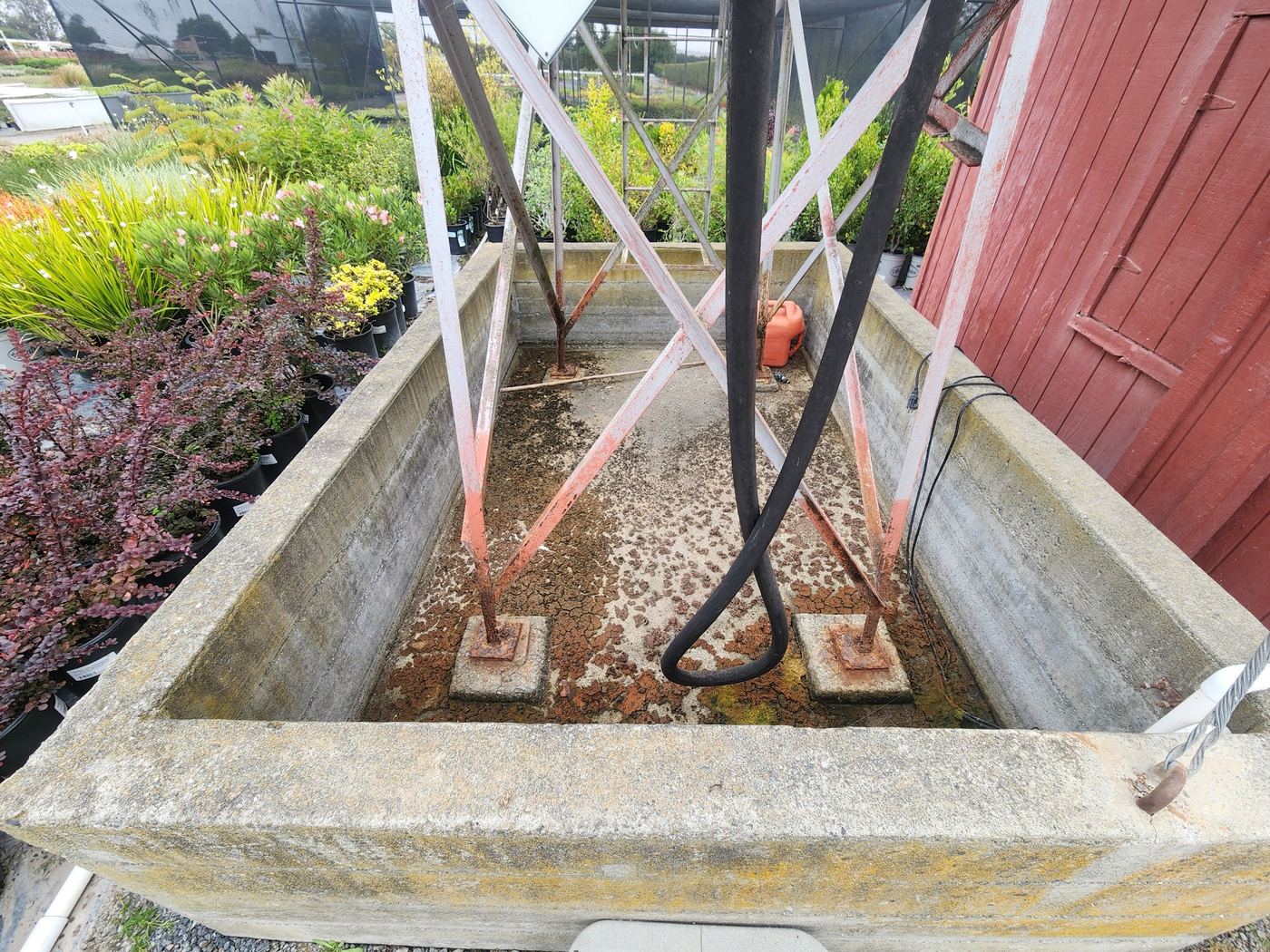 Rusted angle-iron corner posts and cross bracing before repair, Sonoma County diesel tank stand