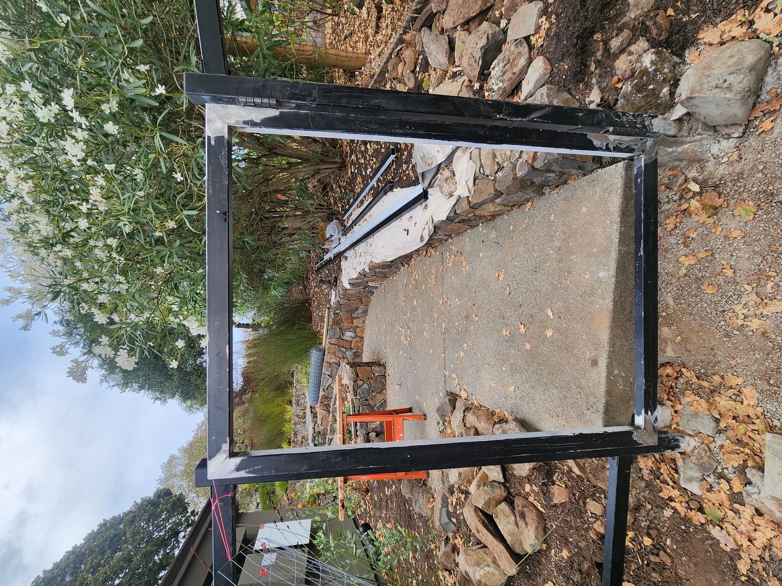 Welded steel gate frame standing in a stacked-stone garden opening in Santa Rosa