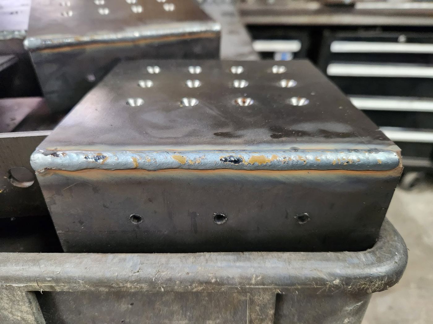 Close-up of a finished weld bead on a steel base plate