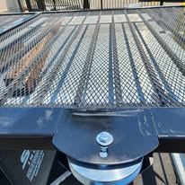 Close-up of a wheel welded onto the bottom rail of a gate