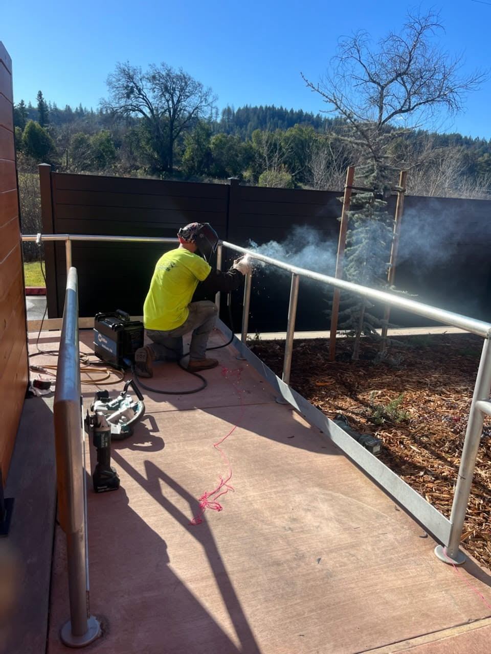 Mobile welding a handrail on-site in Santa Rosa, sparks flying