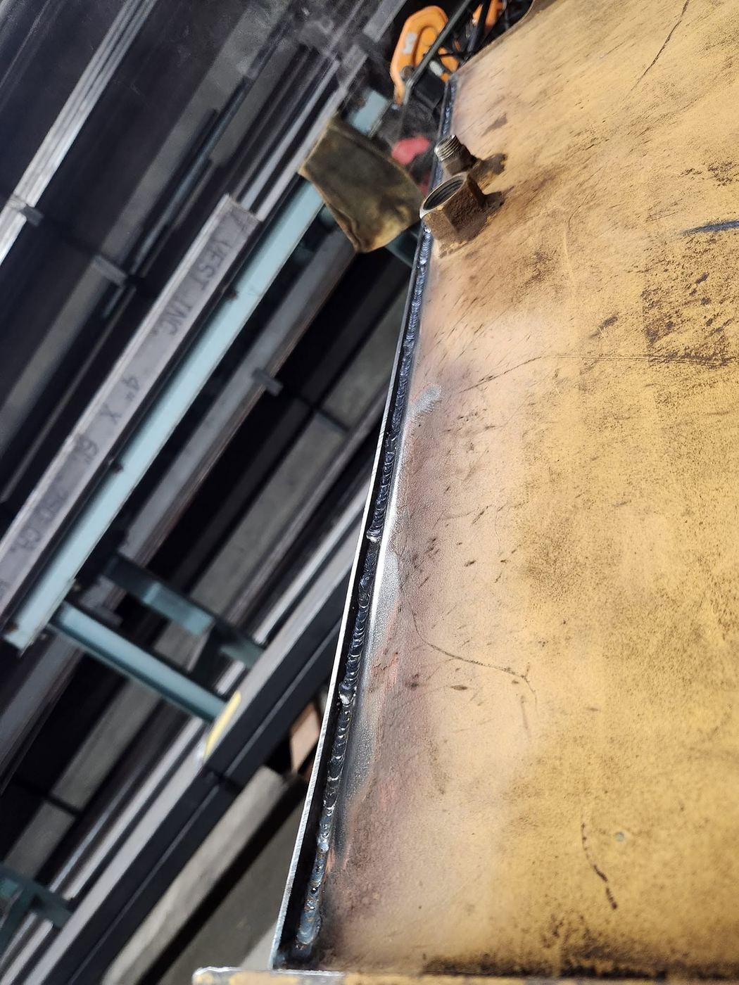Close-up of a repaired weld seam on a tractor fuel tank